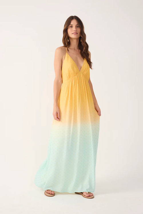 Woman wearing a yellow to blue gradient maxi dress on a white background
