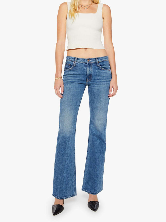 Woman wearing blue jeans and a white top on a white background