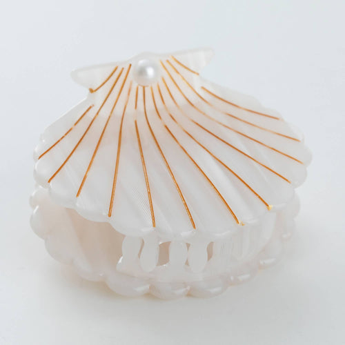 One shell-shaped hair clip with gold lines on a white background