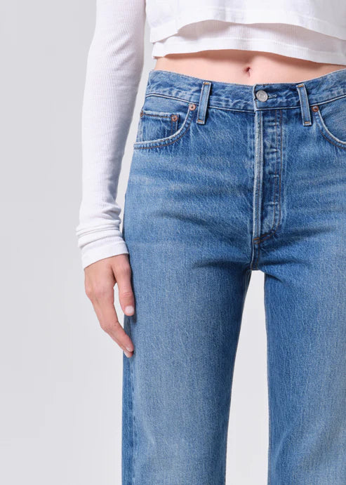 Medium wash blue jeans worn by a woman on a plain background