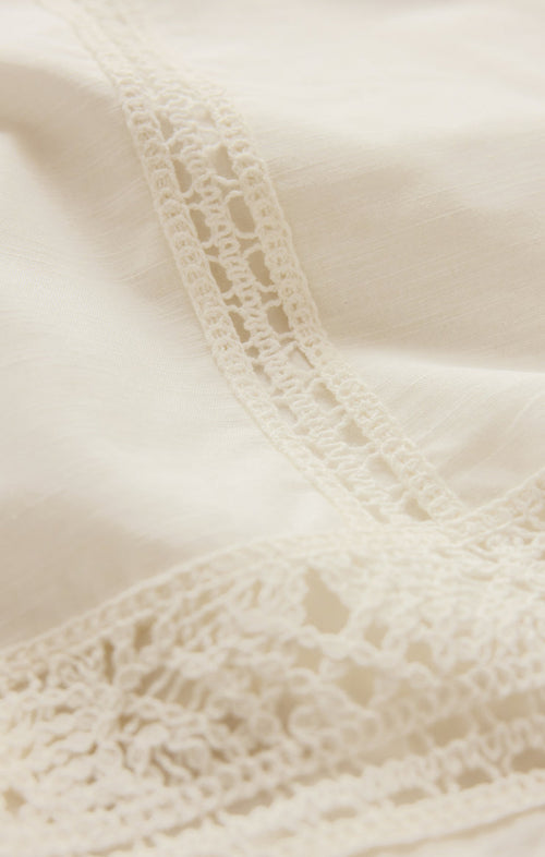 White linen fabric with white lace crochet details.